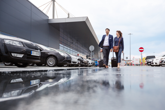 Zwei Personen auf einem Parkplatz direkt am Flughafen Köln
