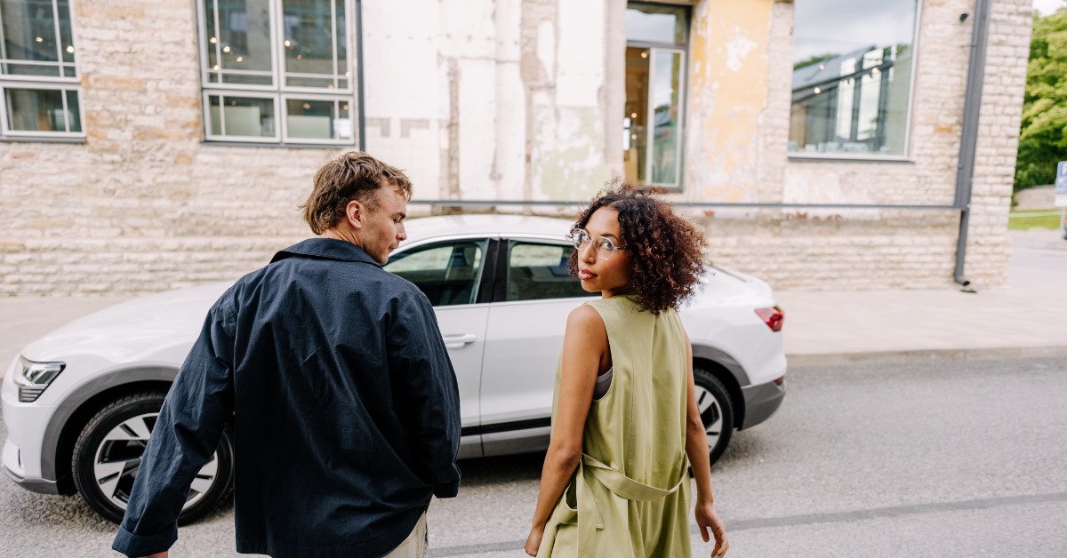 A young man and a girl moving towards a rental car.